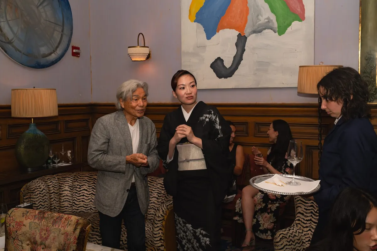 A host in black kimono talking with a guest afterwards