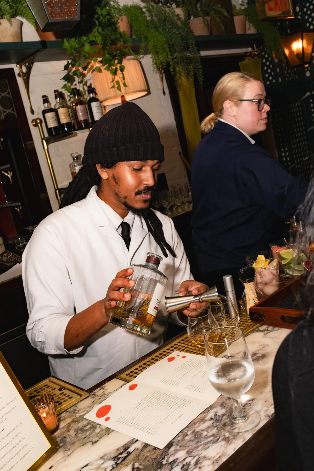 The bartender pouring Suntory whisky at the marble bar