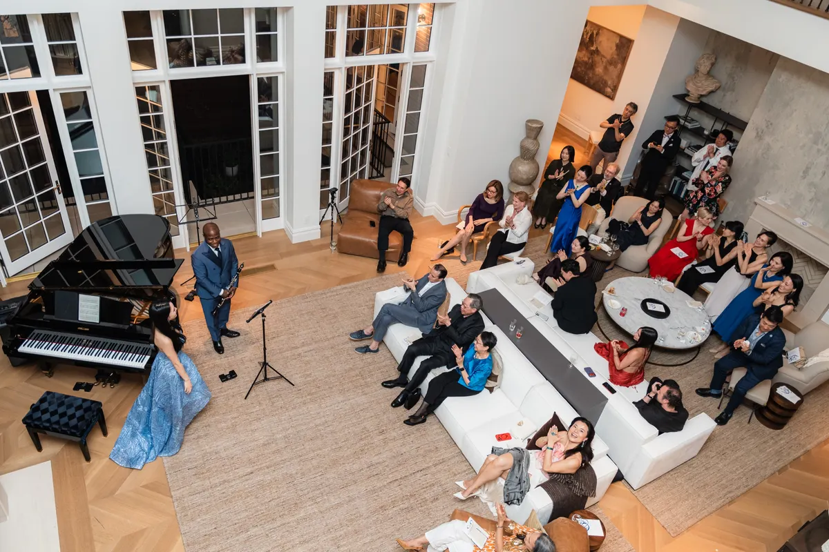 The townhouse salon from the balcony, guests on the sofas around the piano