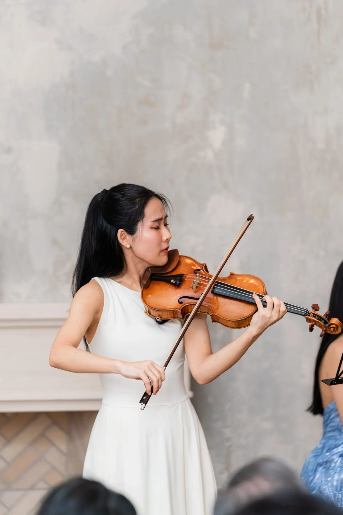 Risa Hokamura playing violin, eyes closed