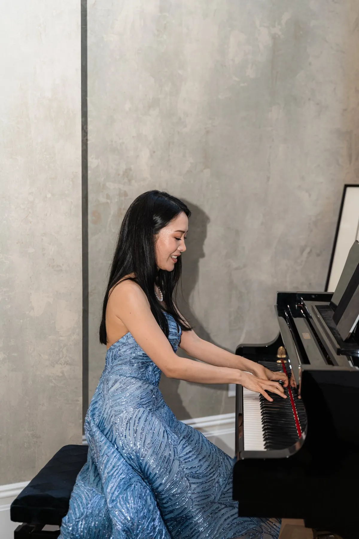 Rieko Tsuchida at the piano in a blue gown