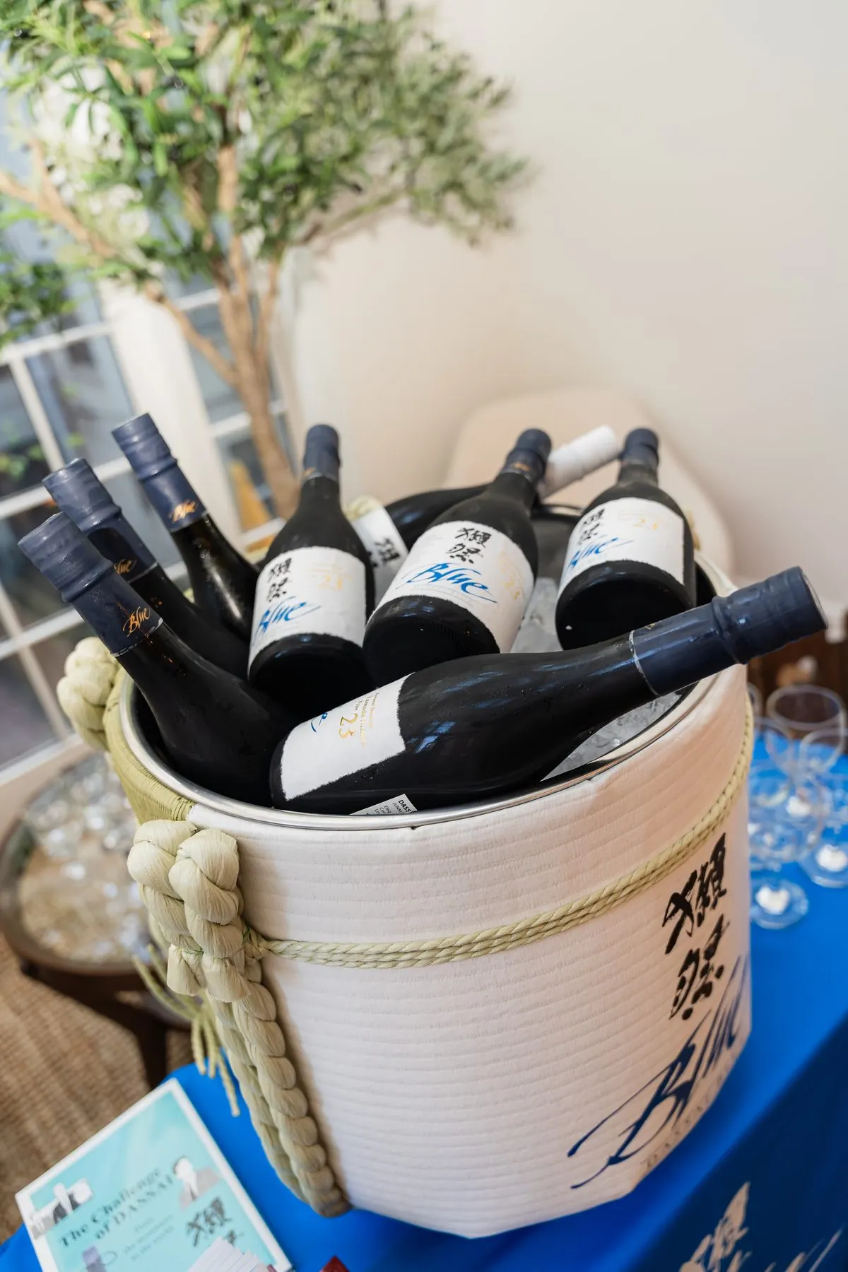 Dassai Blue bottles on ice in a branded barrel