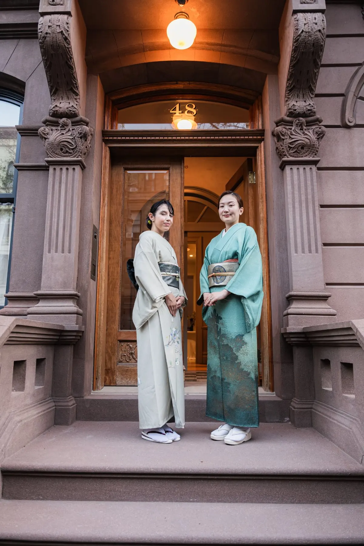 Two hosts in kimono at the townhouse door